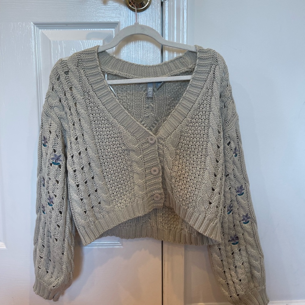 gray/green-ish sweater with flowers on the sleeves